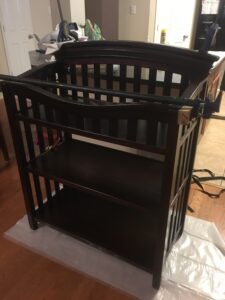 For this custom heirloom piece I used mahogany stained a dark chocolate brown to match an existing crib. The style is a combination of Craftsman mixed with a heavy one-piece crest. To make the crest, a 12 degree arc defines the lines. The profile was routed on a table to achieve the same profile as the crib's rail. The joinery was achieved using a Festool Domino, but mortise and tenon could also be a good option. Each of the shelves are 1/4" mahogany plywood edged with solid mahogany. Severa