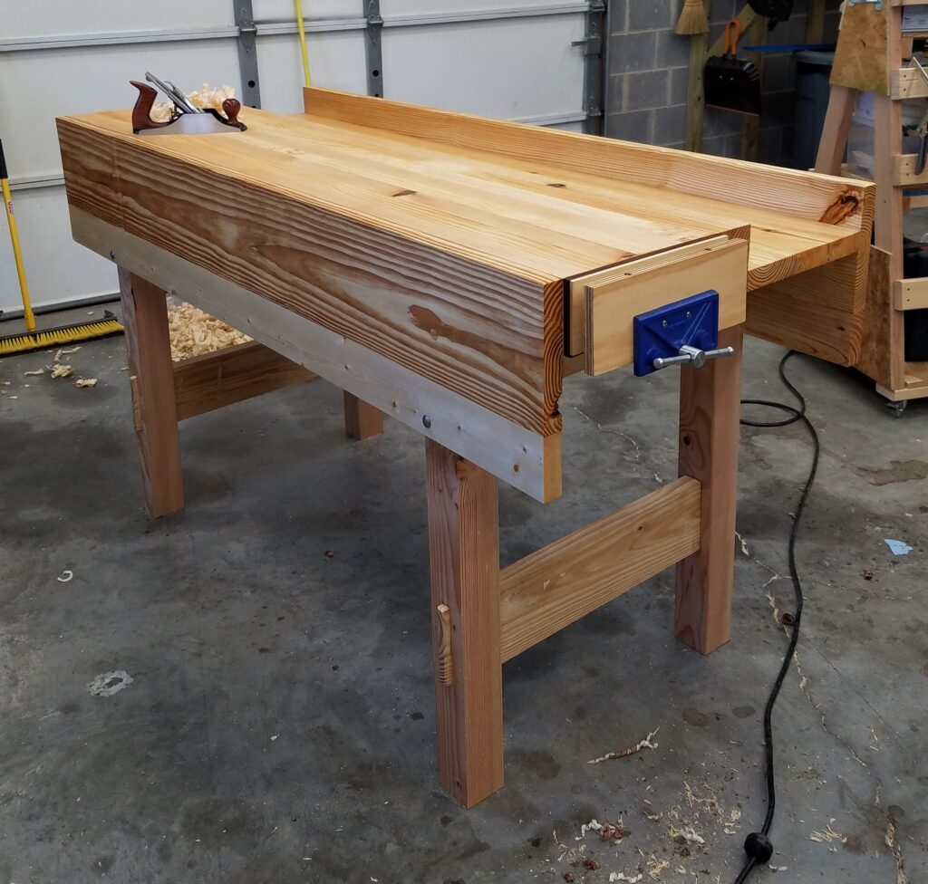 The top, aprons, and wellboard are southern yellow pine that I had in rough sawn 10/4 stock. The rest is kiln dried construction lumber from Home Depot. I'm quite tall, so the benchtop stands 41" high and is 4.5" thick. The joinery in the leg frames is far from perfect. This is my first piece of "furniture" and the first thing I have made larger than a dovetailed box. When I get the face vise mounted, I'll be done. I am so excited! I love this bench, warts and all! I can't wait to start using it!