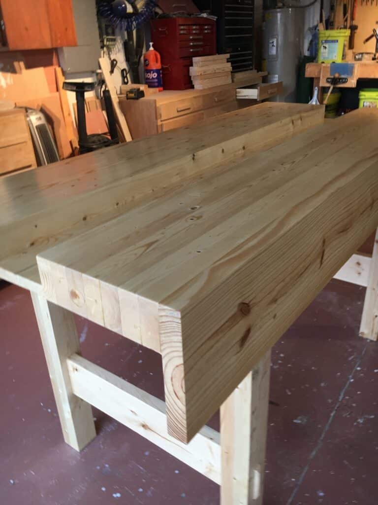 My new Workbench made from 2x4 and 2x6 stud grade lumber. Not the clearest but with some work it planed up well. Glued the leg frames and wedges as I do not intend to break it down. Finished with shellac mainly as a sealer as I am in a high humidity area and wanted to help make the wood stable. Rubbed with very worn 240 sand paper, and finished with 0000wire wool and wax.