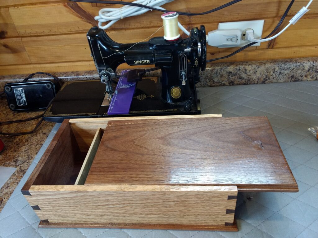 Dovetail box of White Oak and Black Walnut. I made it for my wife to store her manuals, tools and foot pedal for her Singer Featherweight sewing machine that she pieces all her quilts with.
