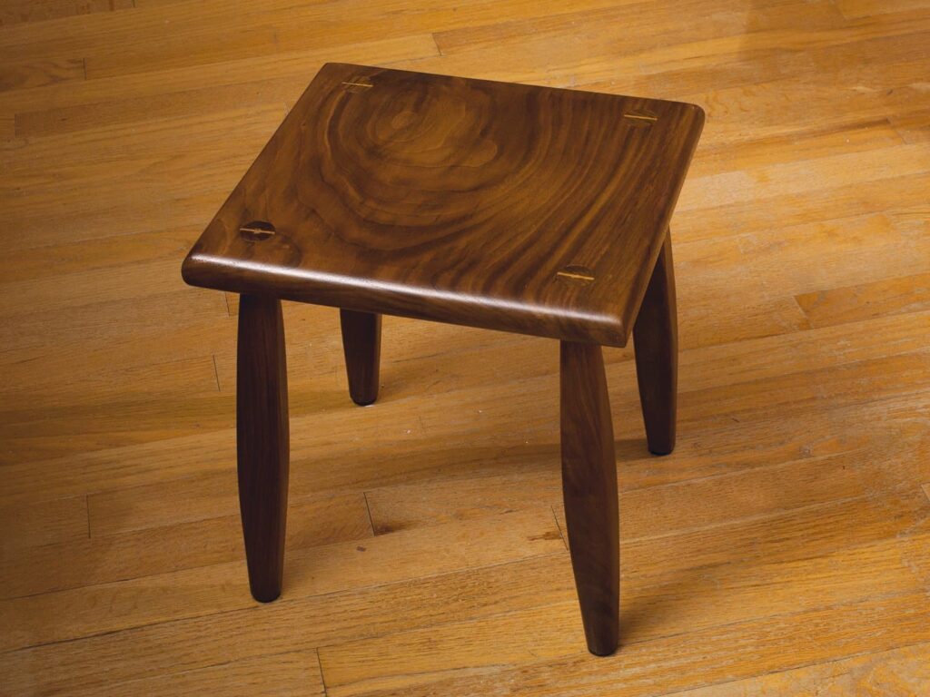 Black walnut footstool finished with blonde shellac. I used maple for the wedges to add a little contrast. The first piece of furniture I've made.