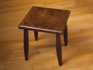 Black walnut footstool finished with blonde shellac. I used maple for the wedges to add a little contrast. The first piece of furniture I've made.