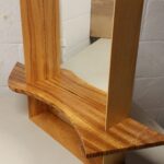 A mirror frame made of Ash with a shelf made of Zebrawood. The shelf is actually inset into the frame and the sides of the frame are beveled to create a depth.