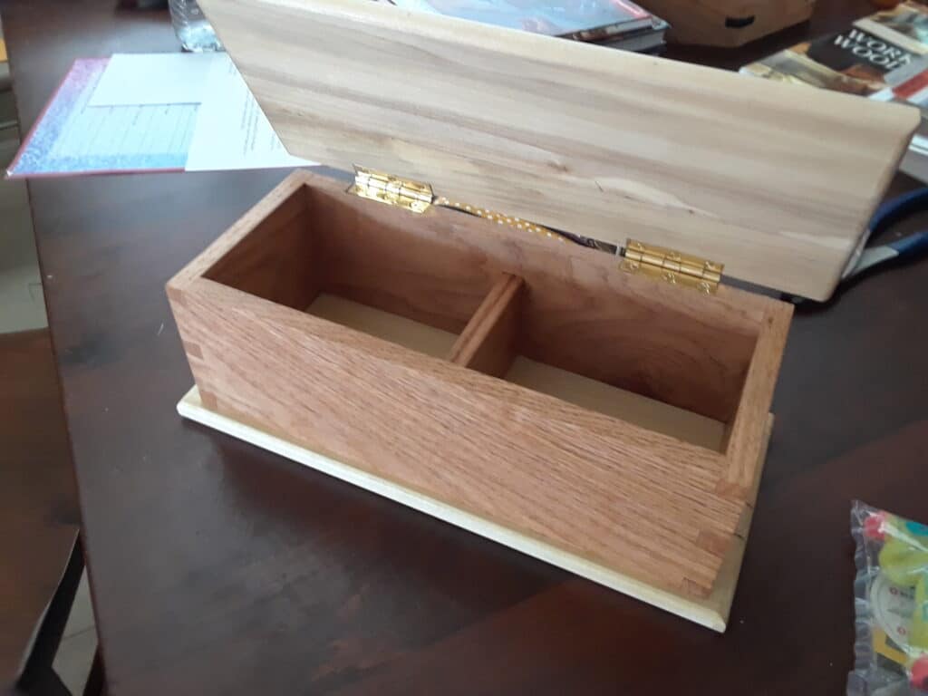 Red Oak and Poplar Dovetail box with a housing dado divider. Finished with clear shellac and wax. I made this for a silent auction my wife was having for her school choir. Couldn't compete with the coupon for hair styling but it had the most bids. Ha!