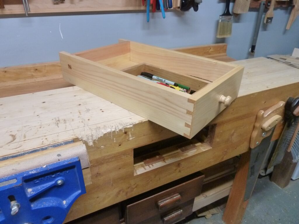 Workbench Drawer made of pine. All done with hand tools. Blind dovetails and housing dado with wedged through mortise like Paul showed in the 5 episode series.