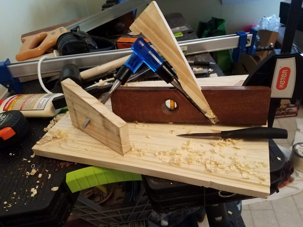 This is the first plane I've made. The wedge is ugly, the chisel is rusty, but boy does it work! I used a section of an old wooden level as the plane body, not sure of the wood. Maybe rosewood? Also pictured is the poor man's router used in the project. Thanks so much to WWMC team for putting such great info out there!