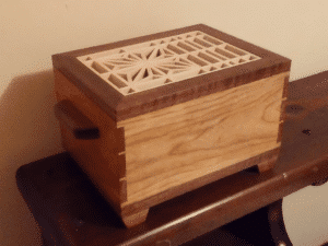 Walnut and (either cherry or birch, other?, not sure) with basswood kumiko pattern inset on top.