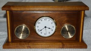 Three in one built on the Paul Sellars plan. This holds a Clock, Thermometer and Barometer. Made from American Black Walnut with Maple inlays on the uprights. FInished with standard French Polish and a final polish with Liberon Bison Wax