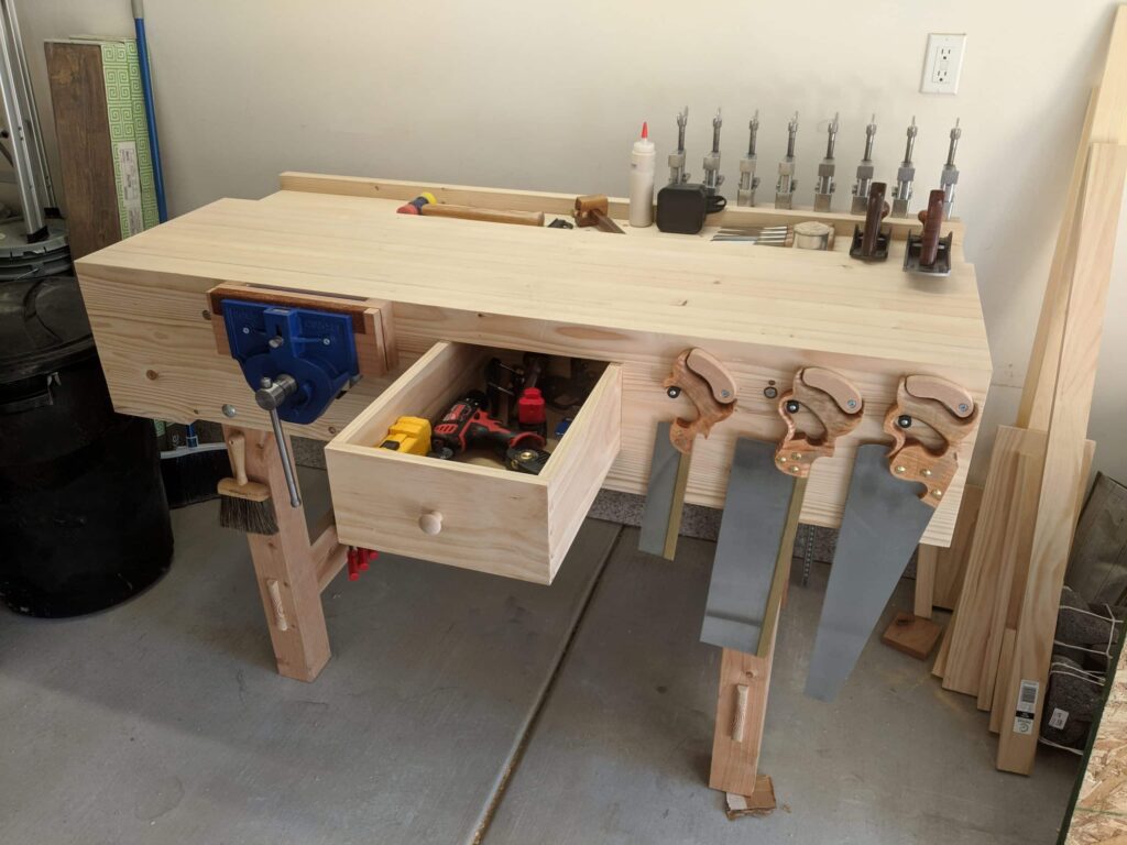 Laminated 2x3 for top and aprons, 4x4 and 2x6 for the legs, laminated 1x6 for the well board, and 3/4 pine for drawers.